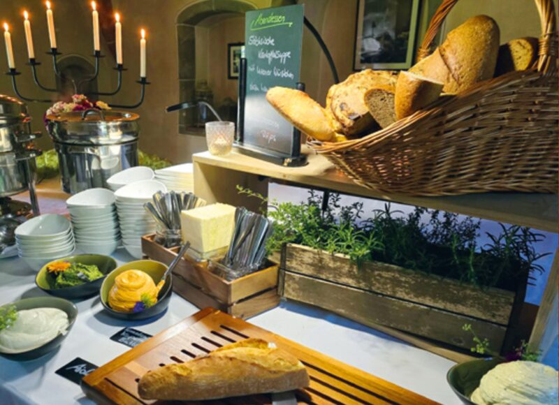 Buffet mit Brot, Kerzen und Salaten